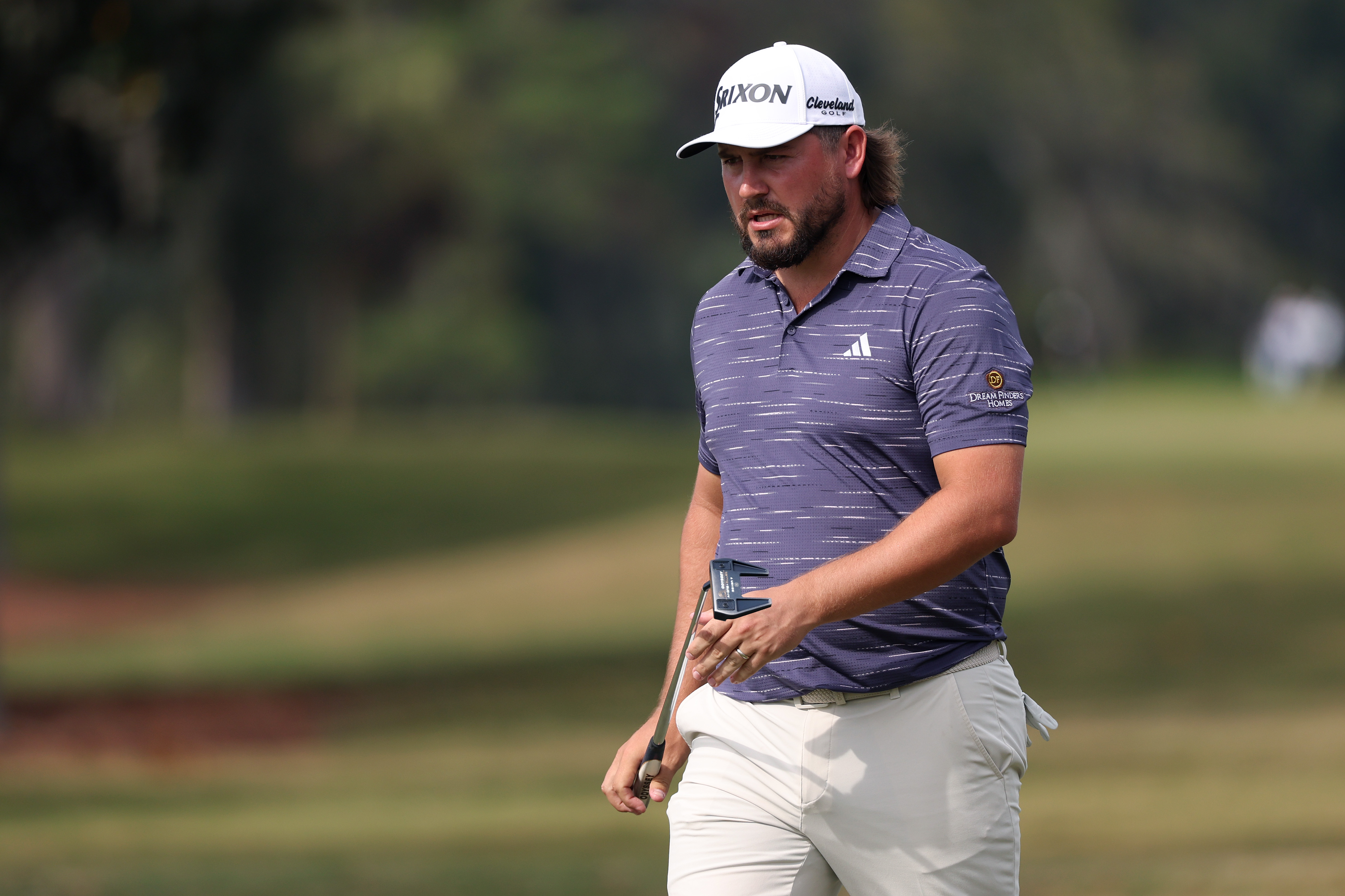 Andrew Novak walks off the green holding a putter