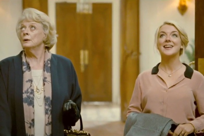 Maggie Smith and Sheridan Smith stand in the foyer of a country house and look in awe up to the ceiling.