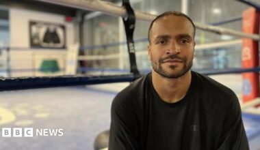 Harlem Eubank sits ringside, wearing a black top.