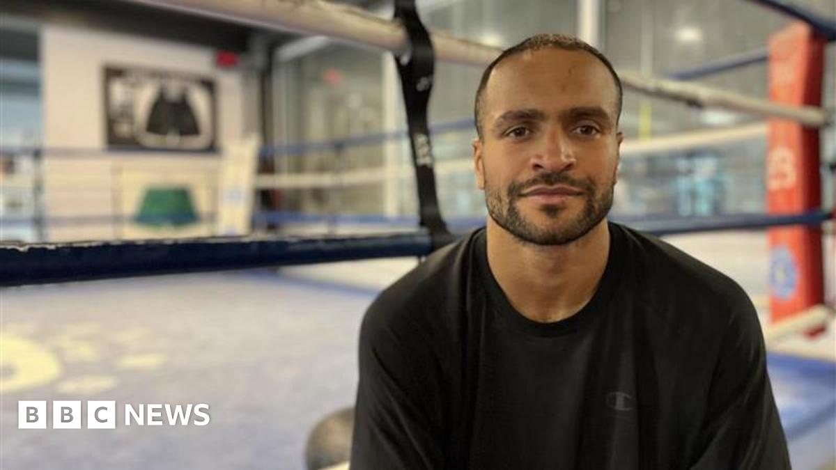 Harlem Eubank sits ringside, wearing a black top.