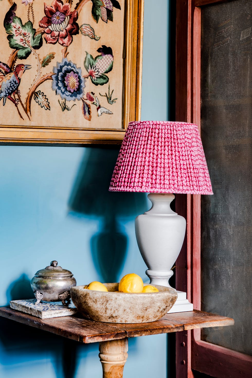 pink lampshade on urn lamp in blue room