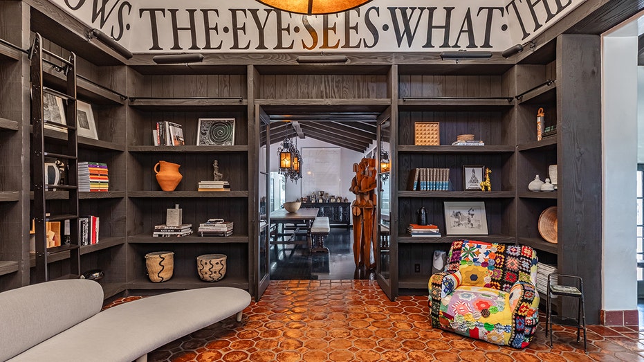 A library with writing on the walls and tiled floors.