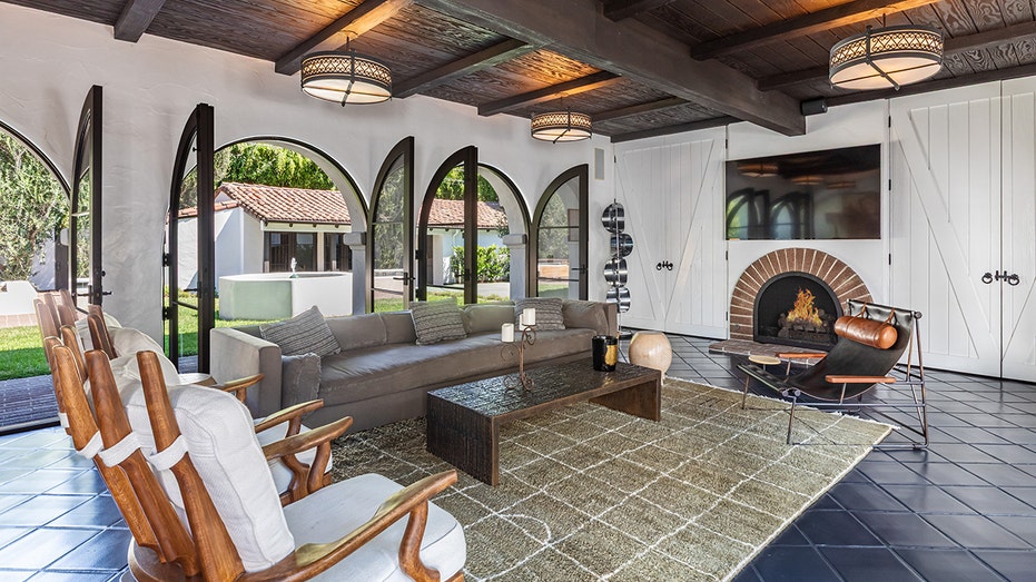 The home also features another sitting room with a flat-screen TV and doors leading to the yard.