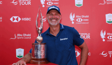 Paul Waring smiles while posing next to the Abu Dhabi HSBC Championship trophy