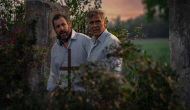 a movie still of Adam Sandler and George Clooney standing in what appears to be a park or forest