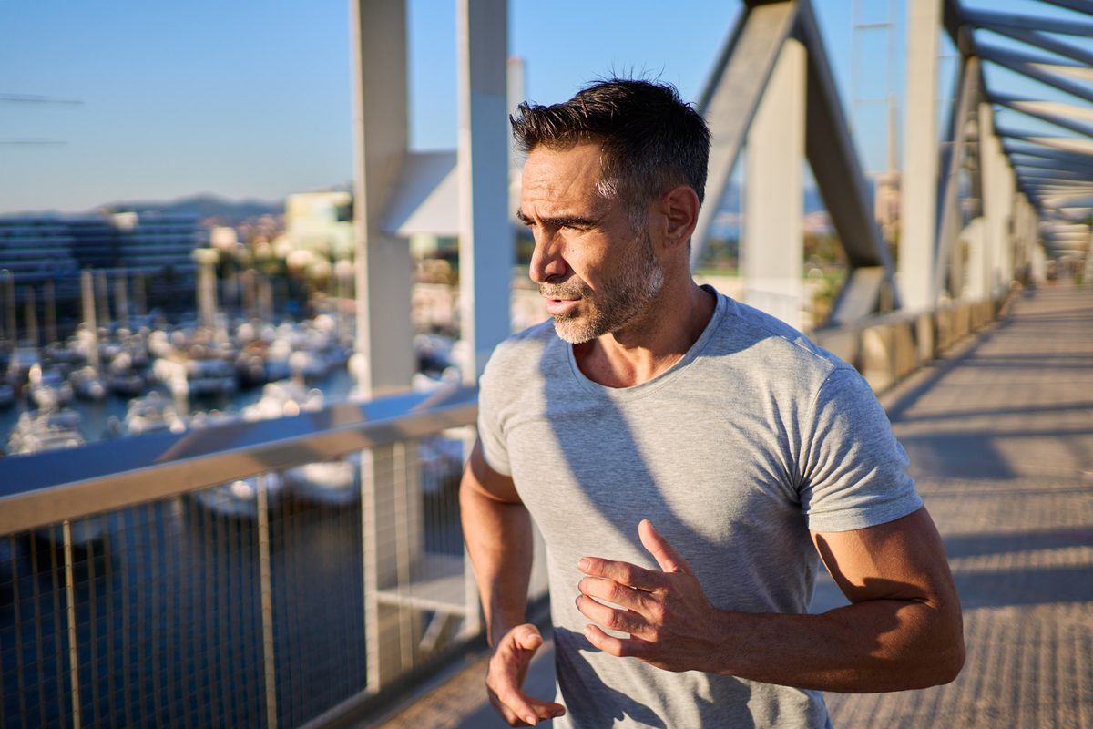 Mature man running on a bridge in the city