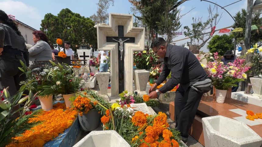 Tomás Jiménez cleans and decorates his father's tomb.