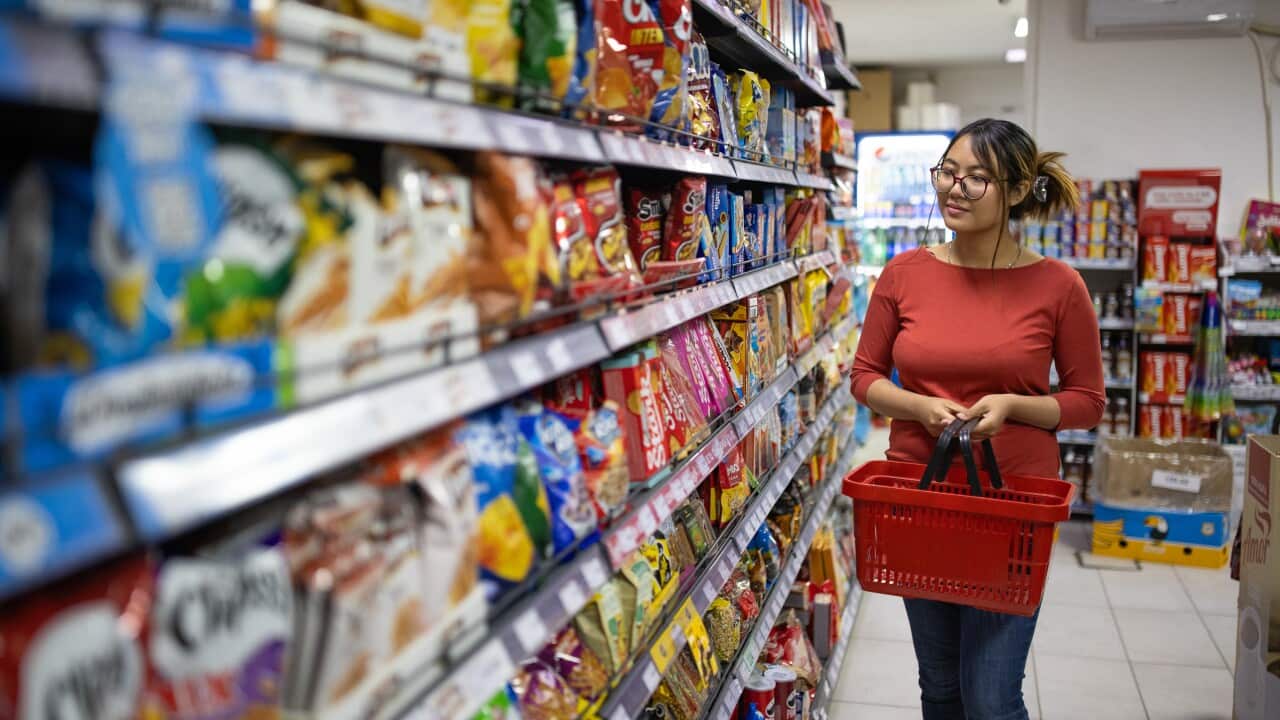 Woman shopping for groceries in a well-stocked supermarket.