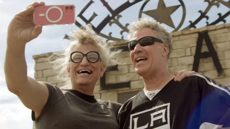 Harper Steele and Will Ferrell take a selfie by a brick building in Will & Harper