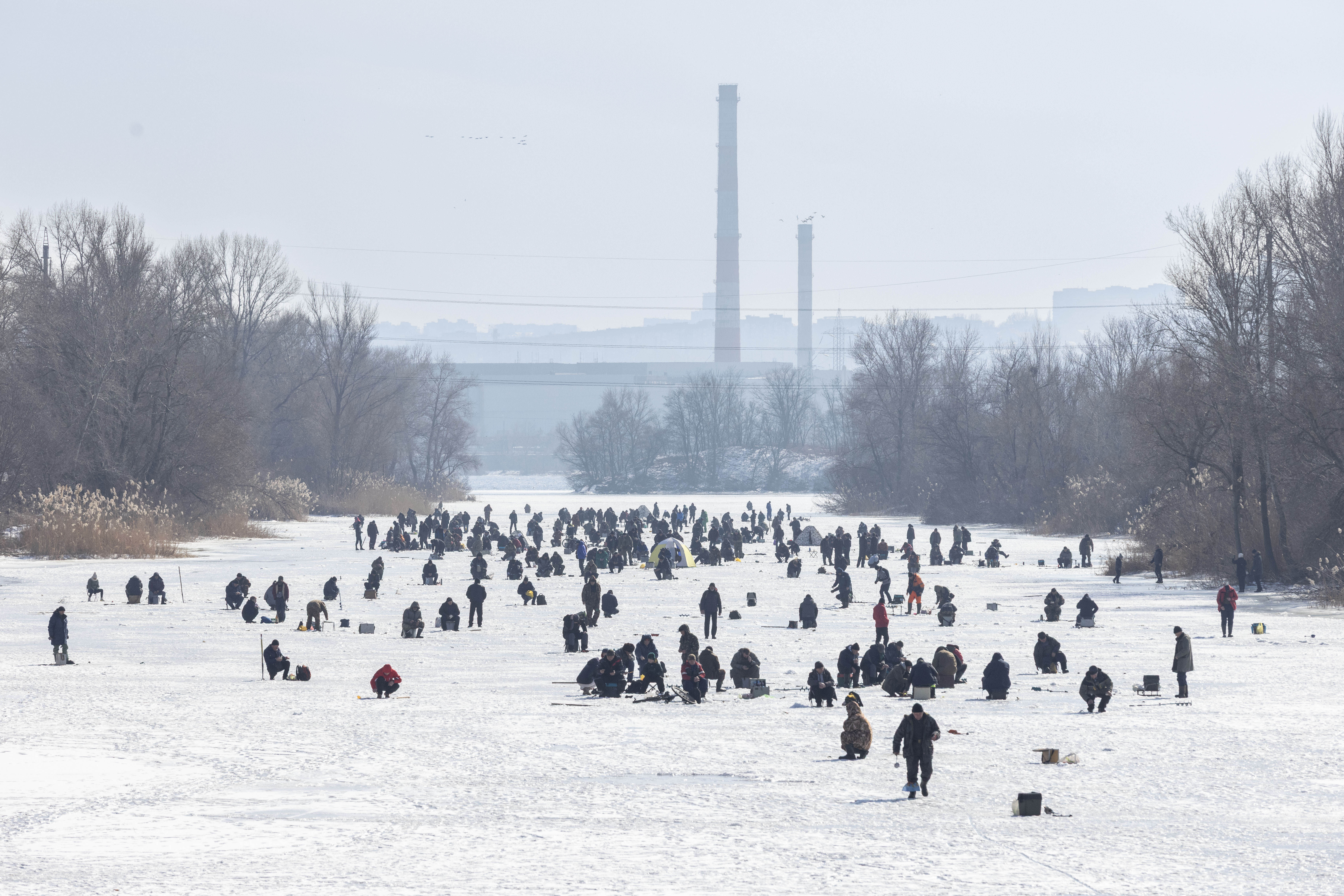 Illiushy Kulyka Street in Kherson, covered with anti-drone netting, with a woman pushing a child on a tricycle.