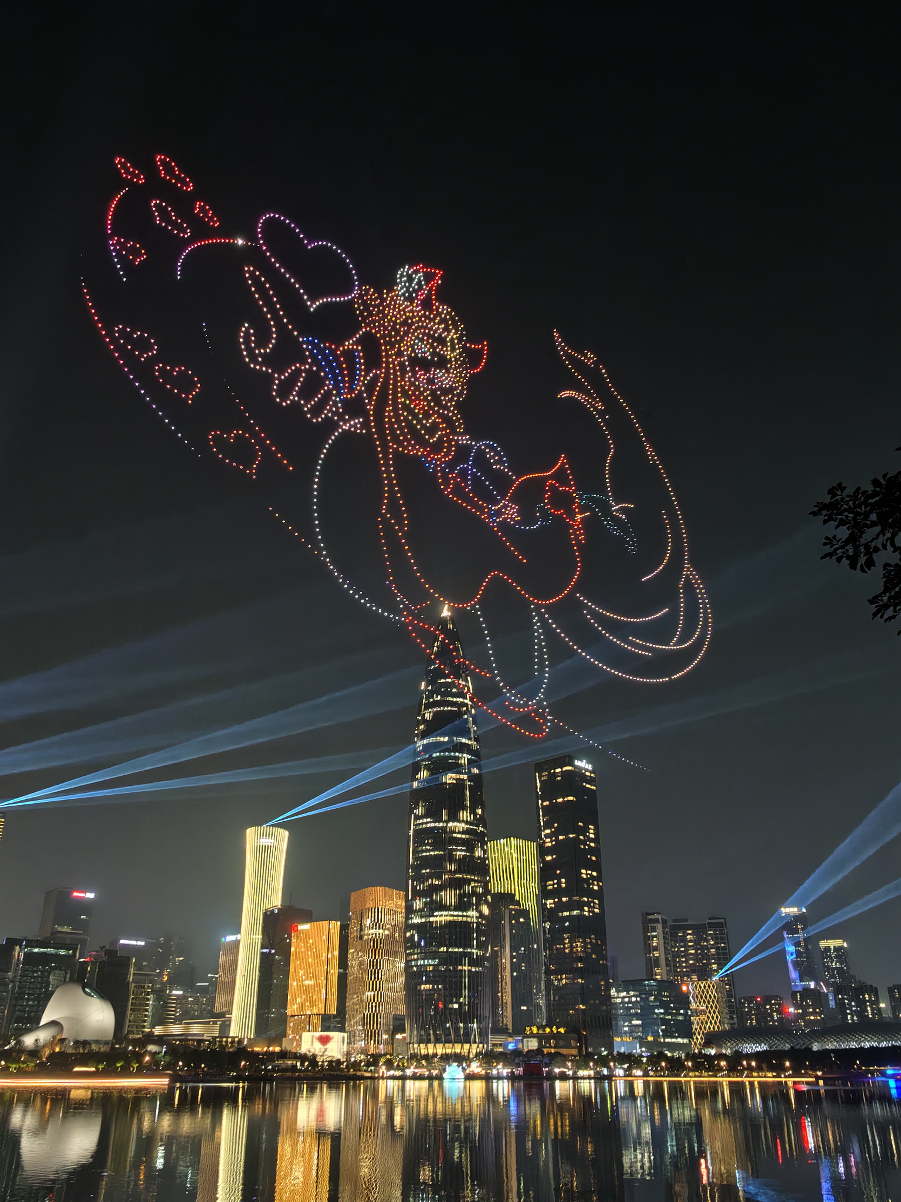 Drone light show forming a character in the sky above a cityscape at night.