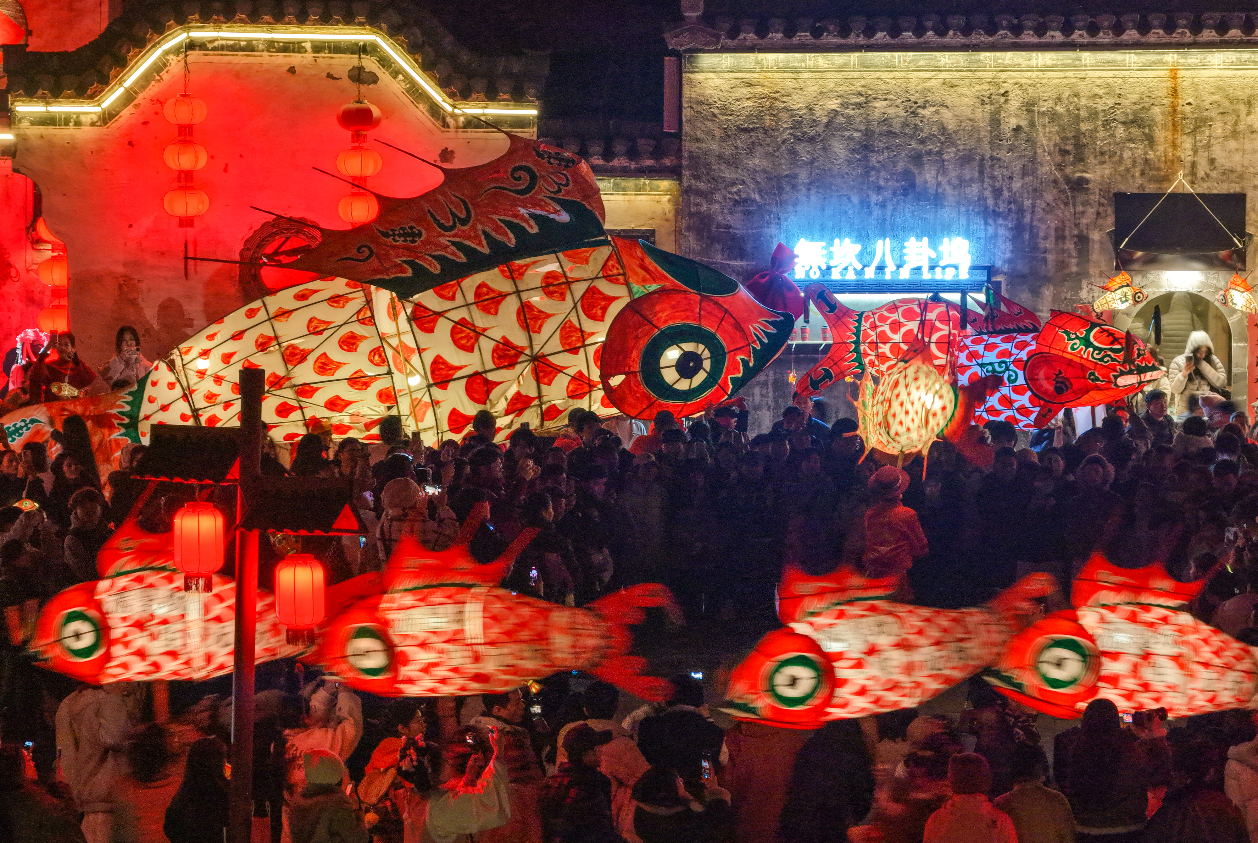 People participating in a traditional parade of fish-shaped lanterns in Huangshan.