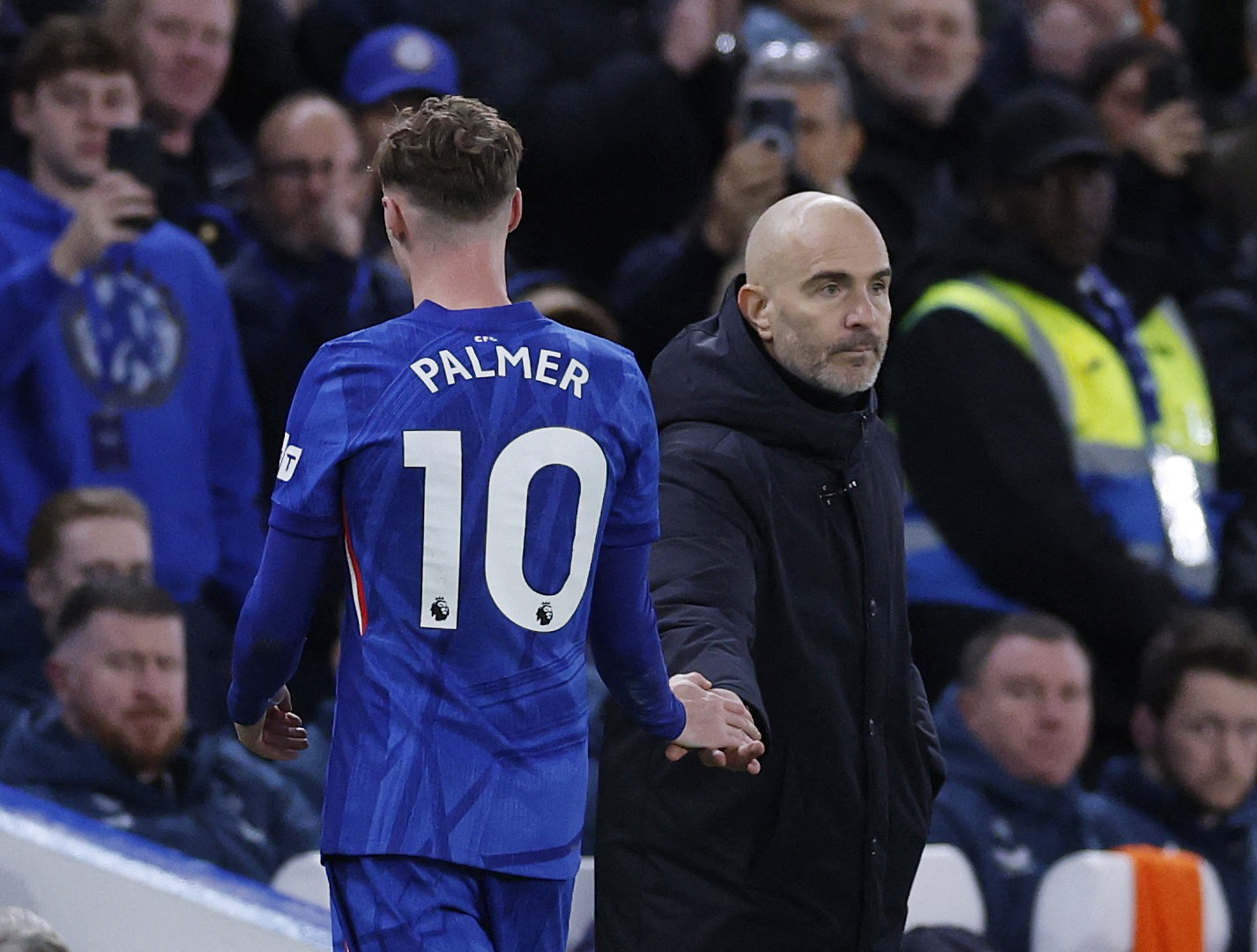 Chelsea's Cole Palmer shakes hands with manager Enzo Maresca after being substituted.