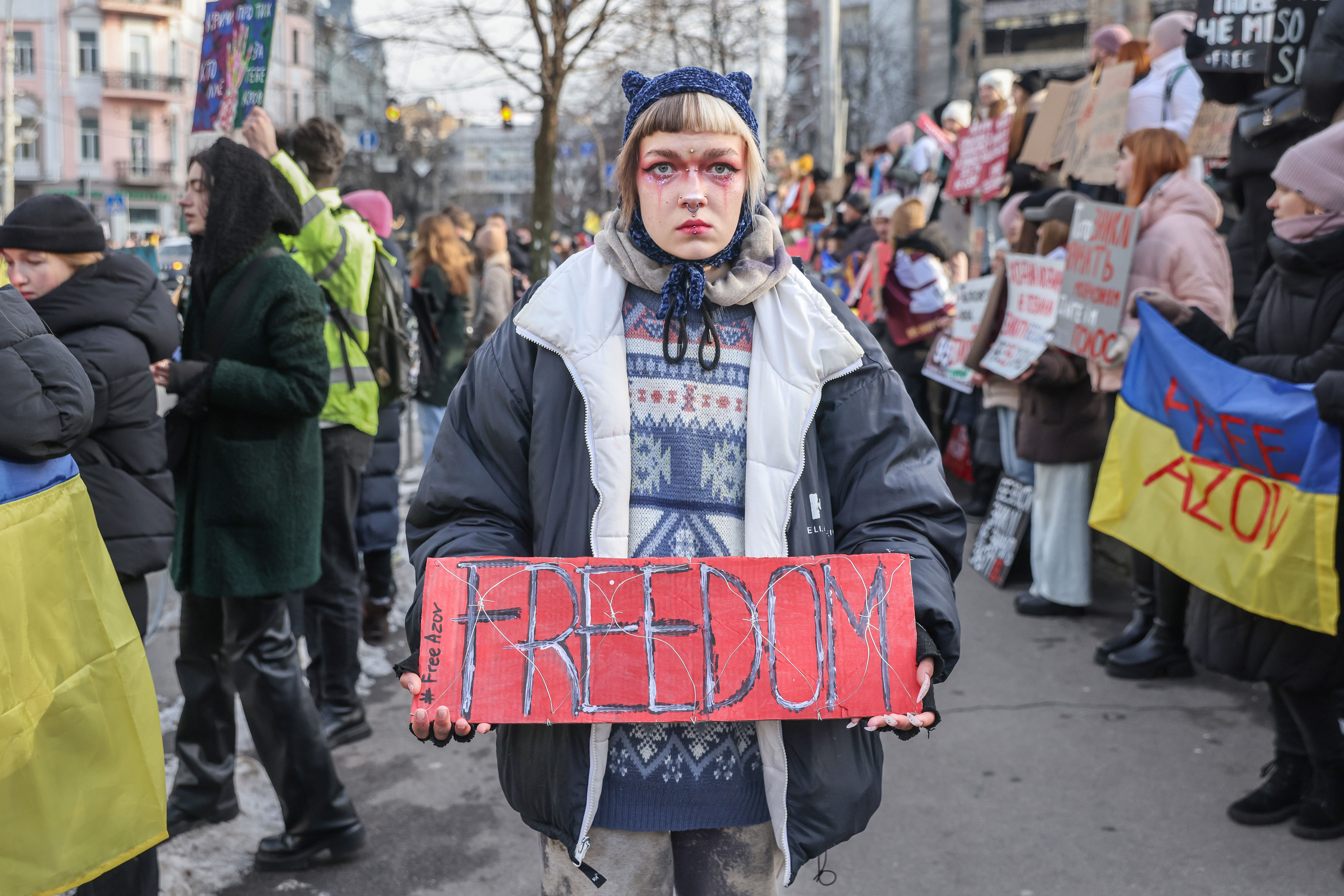 A person holding a "FREEDOM" sign at a rally in Kyiv supporting Ukrainian POWs.