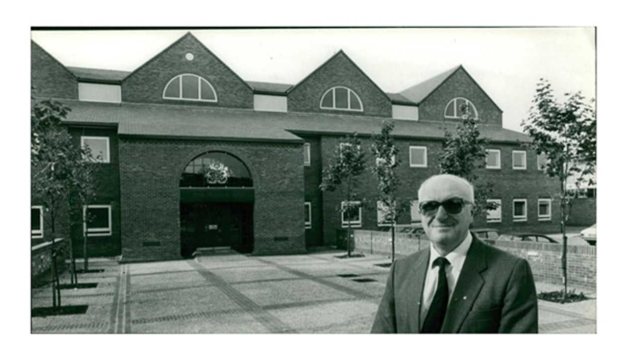 Architect Frank Tucker in front of a brick building he designed.