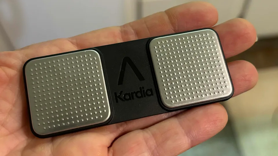 hand holding KardiaMobile portable ECG monitor, portable ecg machine