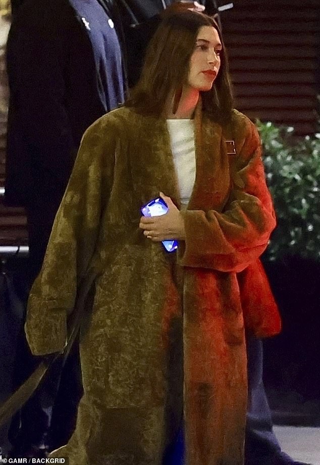 Hailey was wrapped in a long, fuzzy walnut brown coat over a slimming white top and a set of high-waisted jeans for her latest night on the town