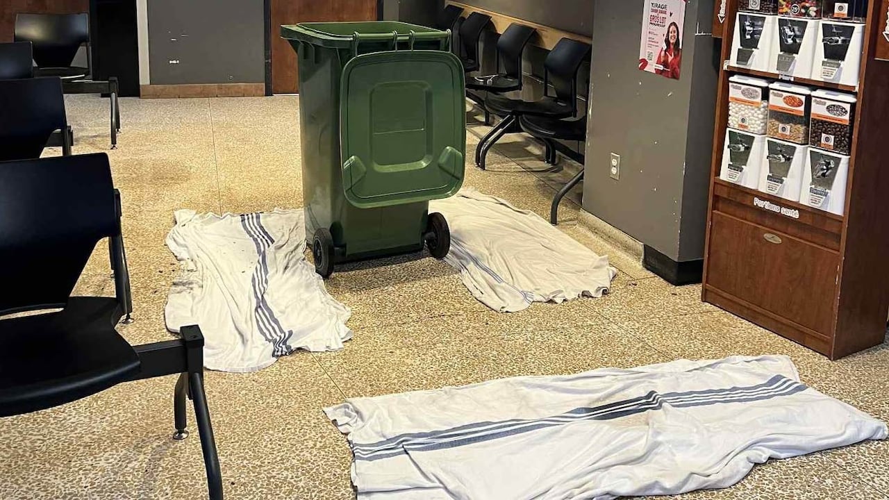 Blankets on the ground to mop up some water and a large recycling bin to collect drips are seen in a hospital.