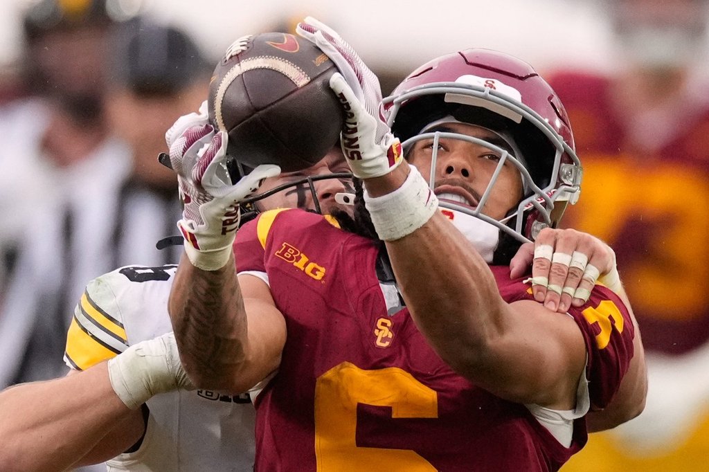 FILE - Southern California wide receiver Makai Lemon, right, makes a catch while under pressure from Iowa defensive back Zach Lutmer during the second half of an NCAA college football game, Saturday, Nov. 15, 2025, in Los Angeles. (AP Photo/Mark J. Terrill, File)