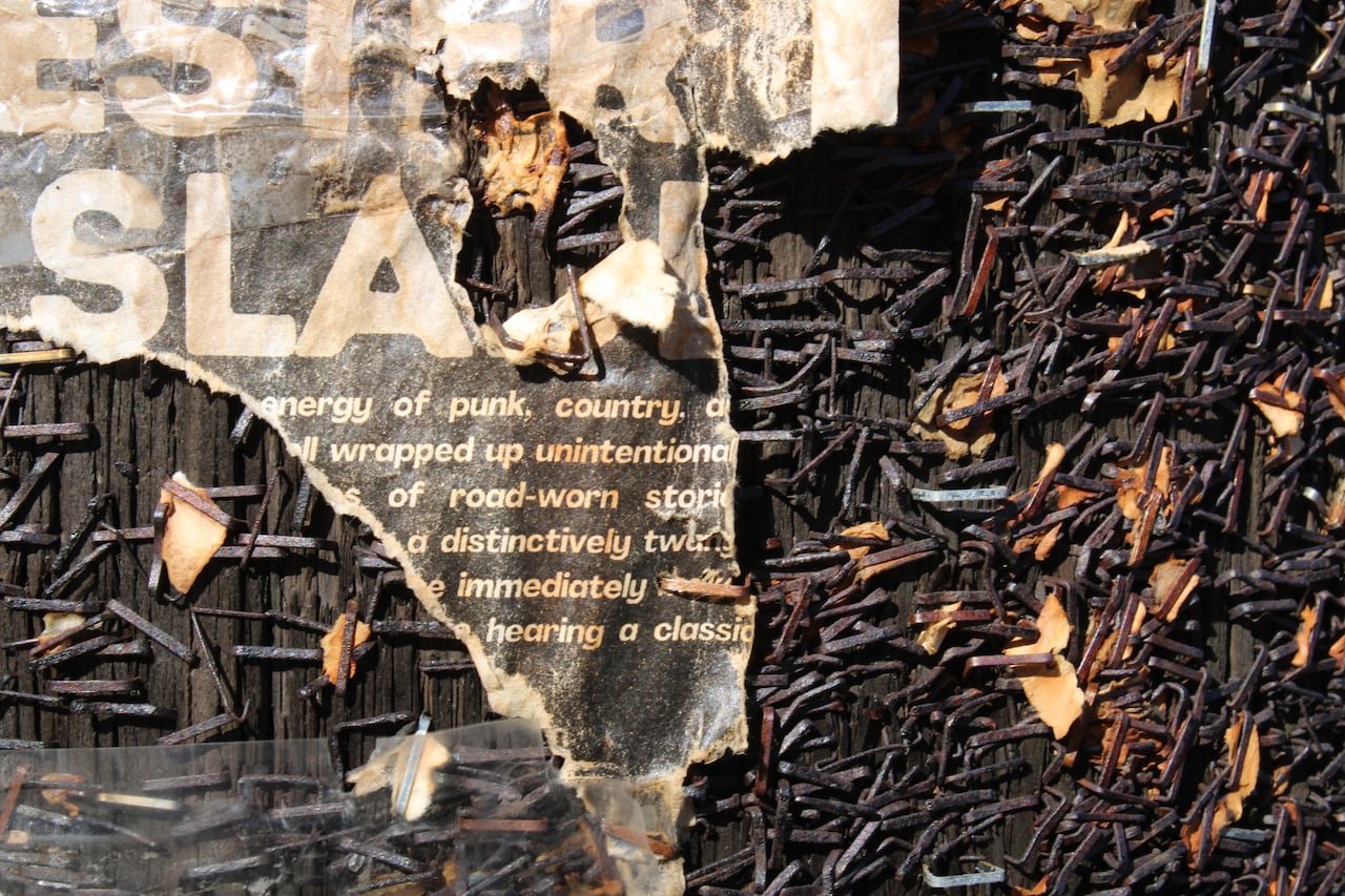 torn poser with words "punk country" on pole with lots of rusted staples