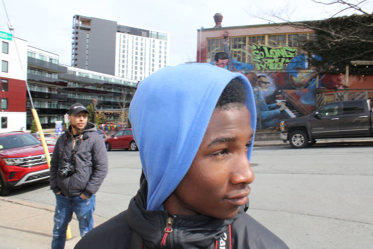 a black boy in a blue hoodie looks to the right
