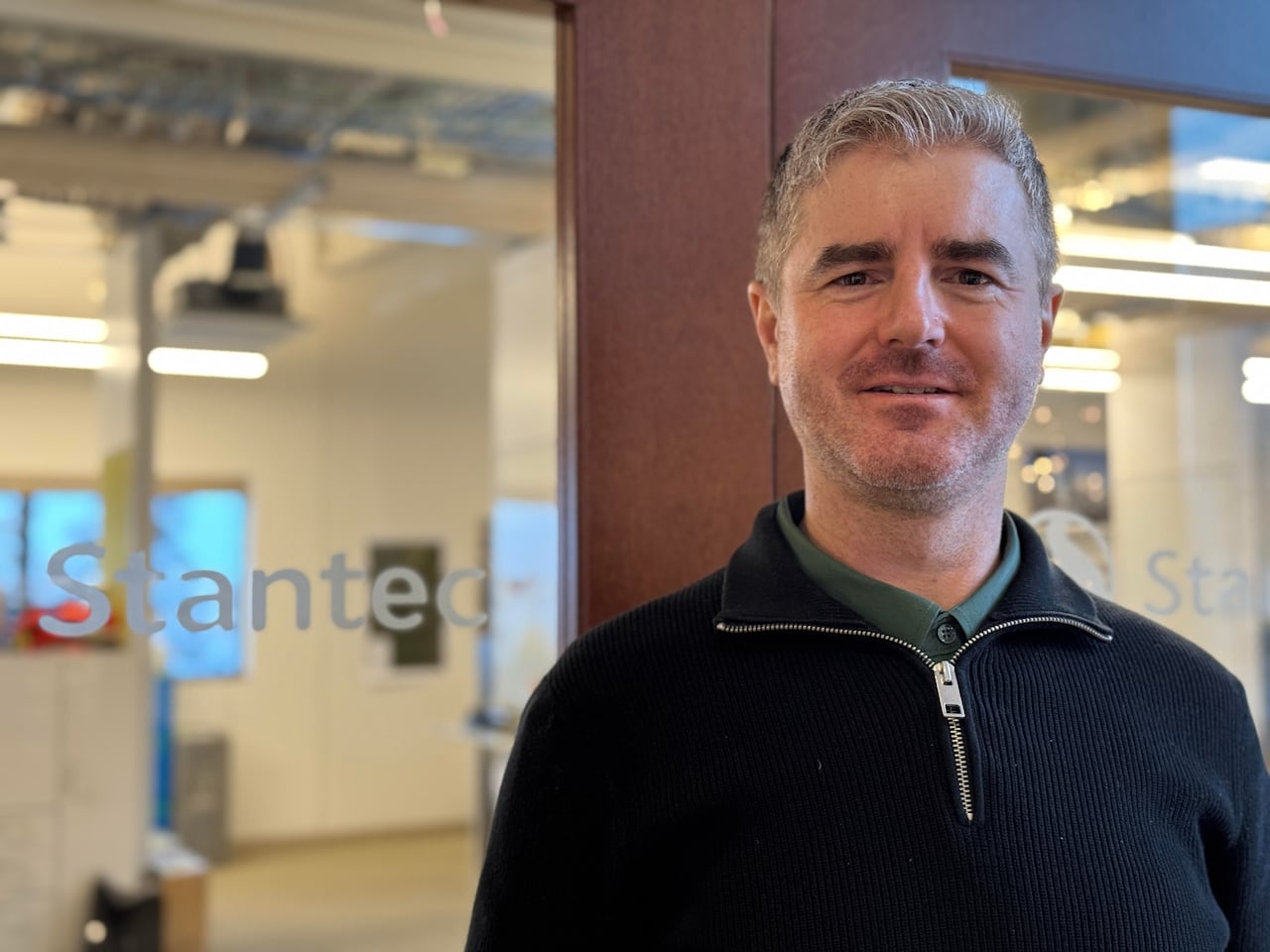 man stands in front of glass door that says Stantec
