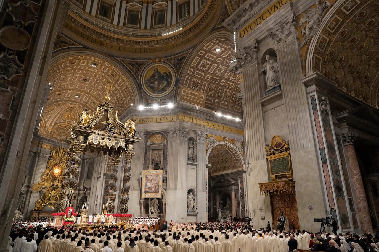 A crowd of people gathers outside a large church
