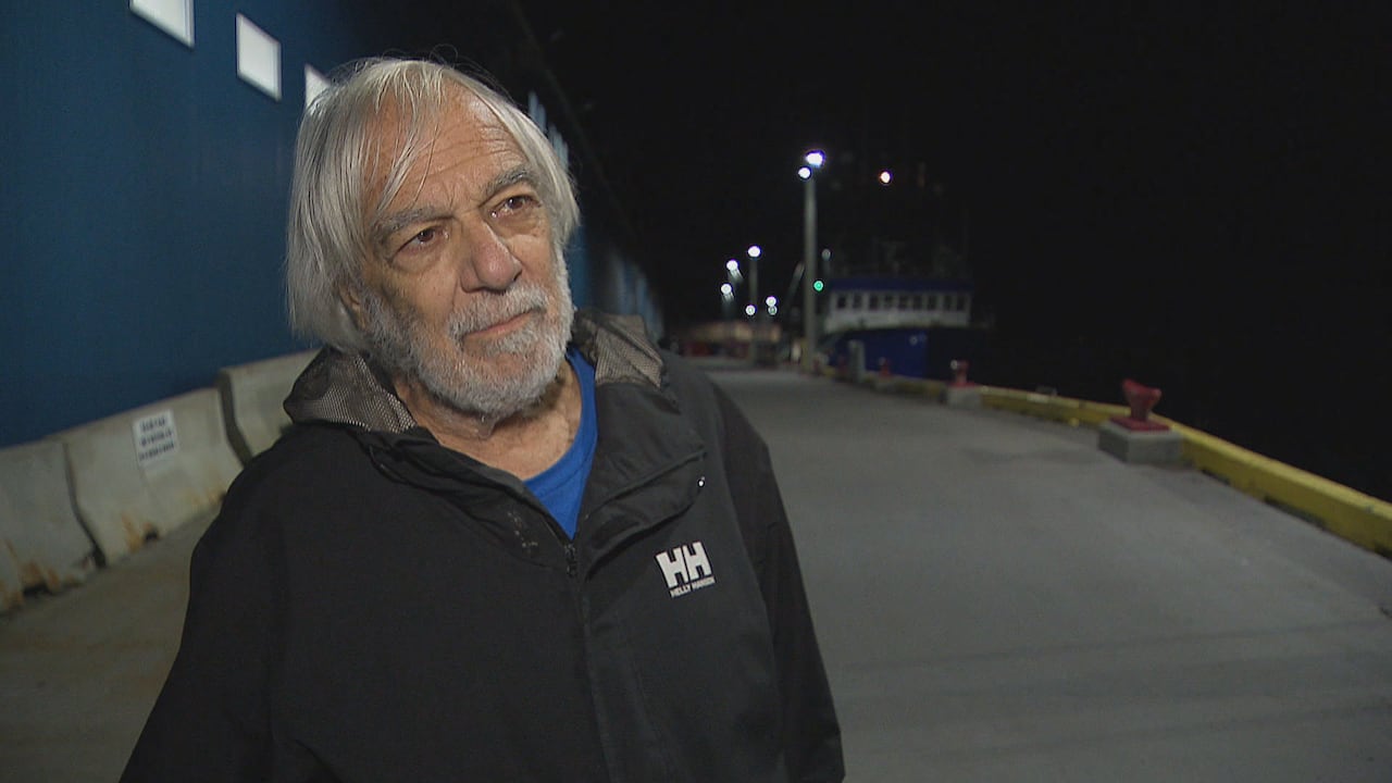 Man stands on the wharf at night.