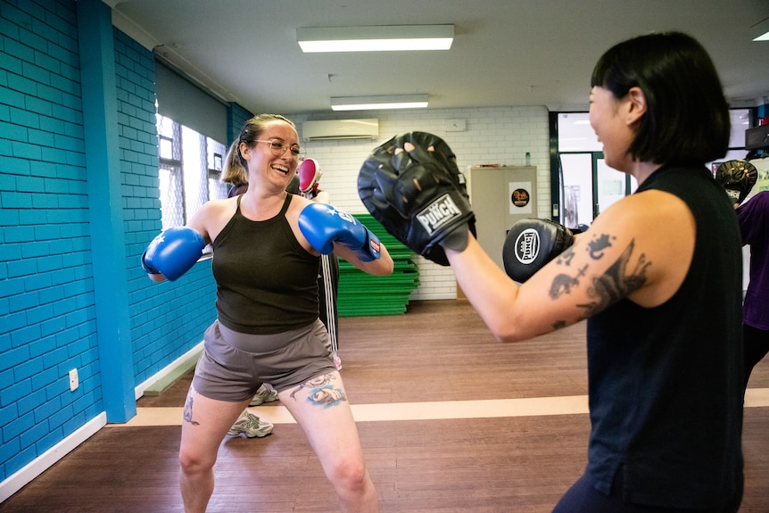 Participants smiling in a boxing class.