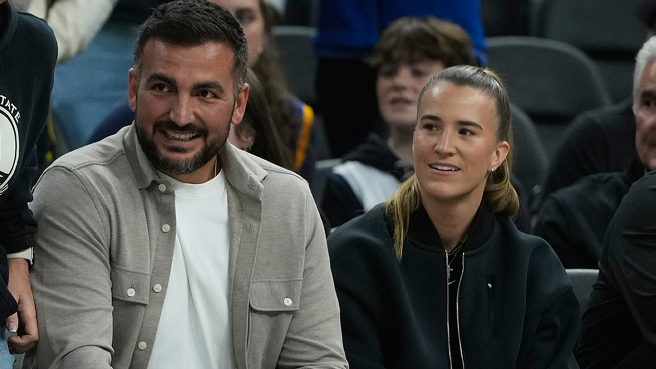 New York Liberty's Sabrina Ionescu sits with her husband, Hroniss Grasu before an NBA basketball game between the Warriors and the Utah Jazz in San Francisco, Monday, Nov. 24, 2025. 