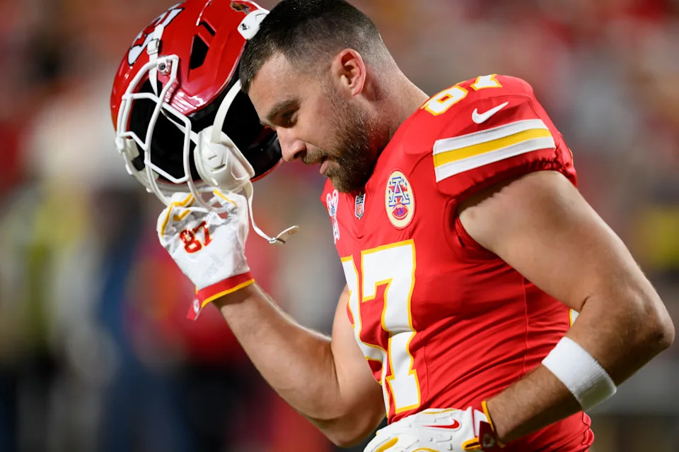 Kansas City Chiefs tight end Travis Kelce takes off his helmet during warmups before an NFL football game against the Denver Broncos, Thursday, Dec. 25, 2025 in Kansas City, Mo. (AP Photo/Reed Hoffmann)