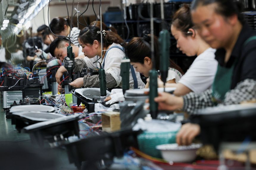 Employees of Gstar Electronic Appliance Co., Ltd work to assemble air fryers in the factory in Ningbo, Zhejiang province, China, on May 19, 2025.