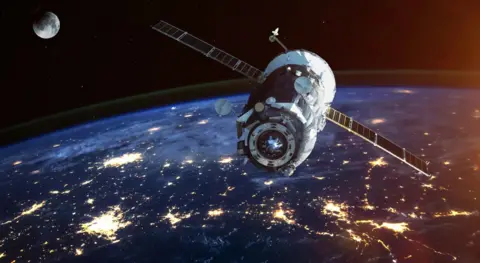 SSTL A satellite up in space. The earth can be seen in the image, as can the moon.