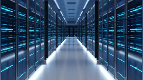 Getty Images A view of a data centre corridor lined with dark cabinets covered in lights. The mood is sinister. 