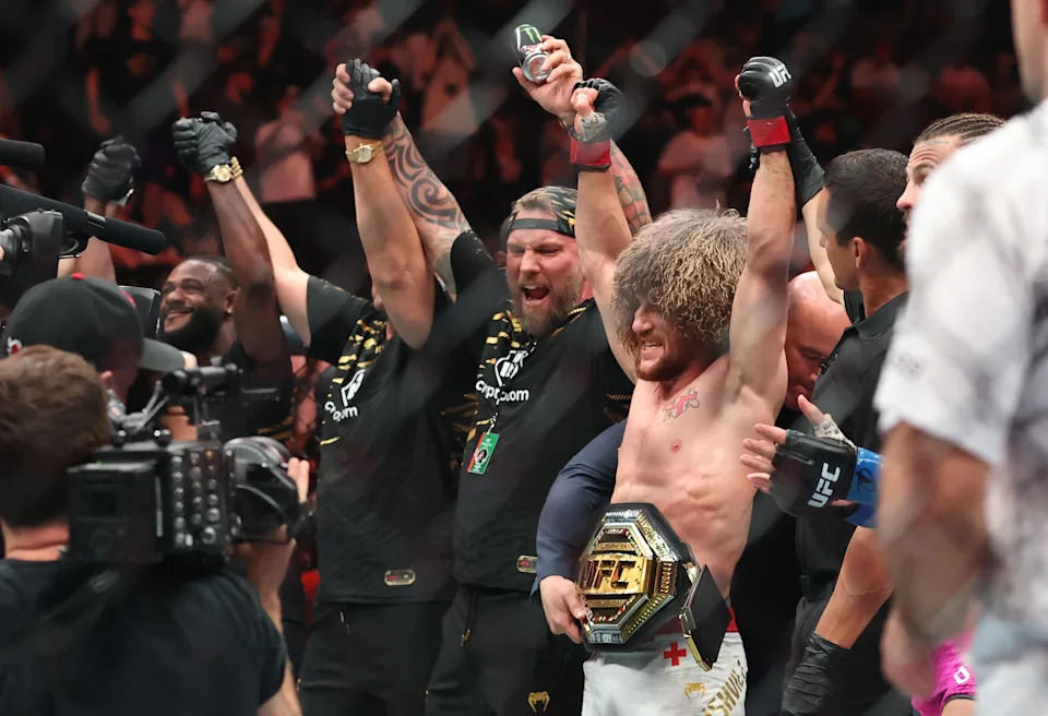 Merab Dvalishvili (red gloves), along with coach John Wood (center), reacts after defeating Sean O’Malley (not pictured) in a bantamweight title fight during UFC 316 at Prudential Center.