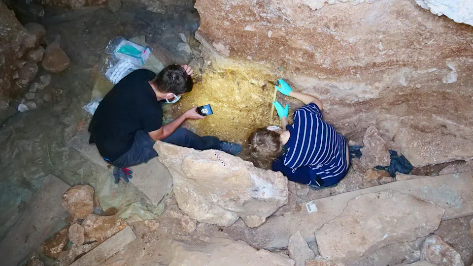 Two people examining the caves walls.