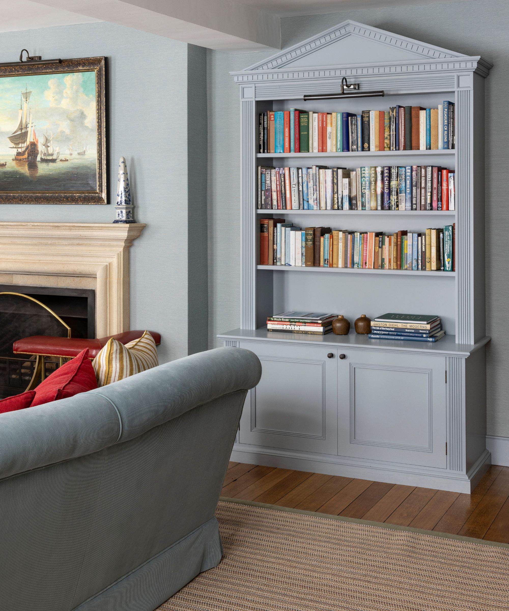 powder blue painted living room with a custom bookcase with a pediment