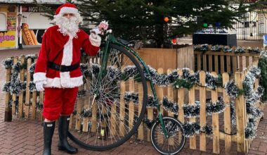 Charlie Burrell with a penny-farthing in a Santa costume