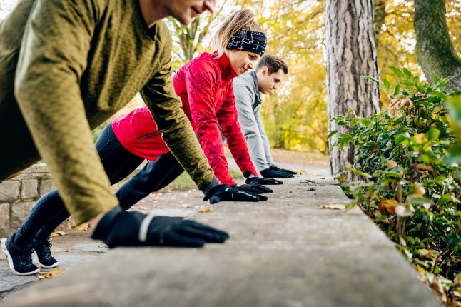 A row of athletes doing push-ups against a wall together.