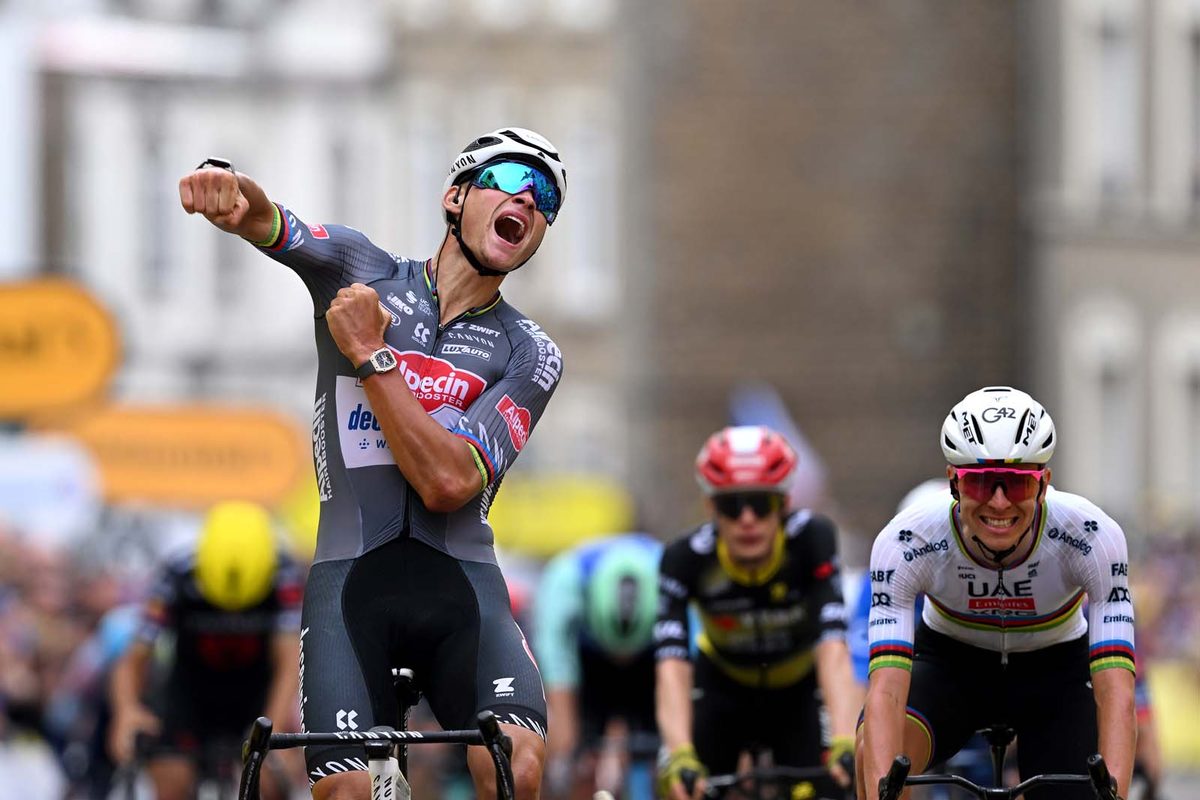Mathieu van der Poel celebrates winning stage 2 of Tour de France 2025 with Tadej Pogacar in background.
