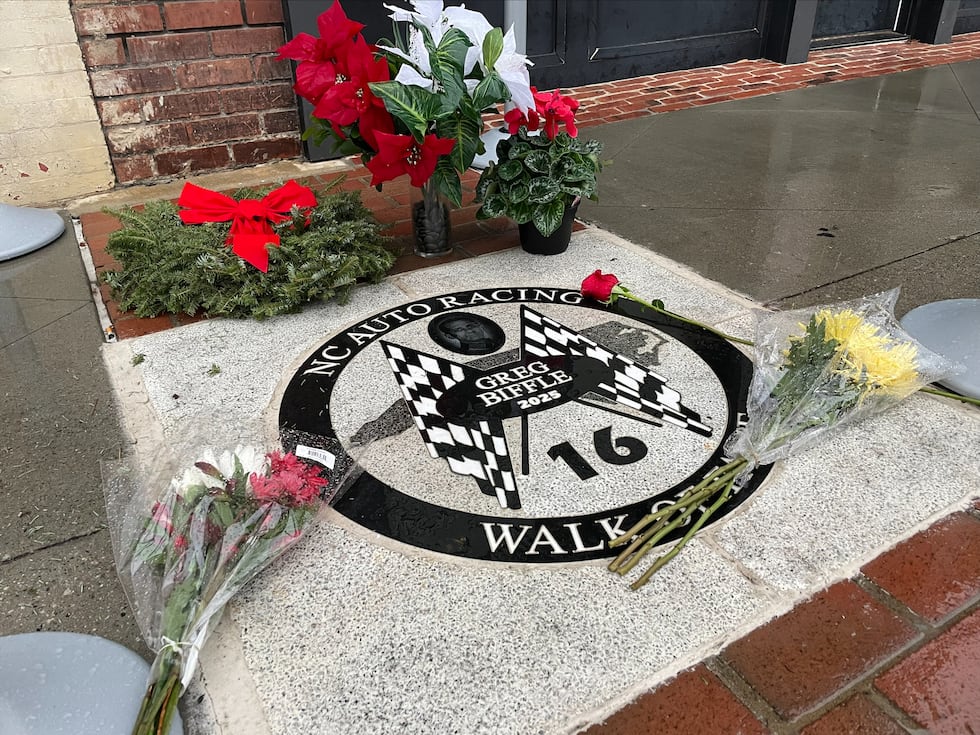 Sympathy flowers lay at Greg Biffle's honorary plaque in downtown Mooresville, signifying his...