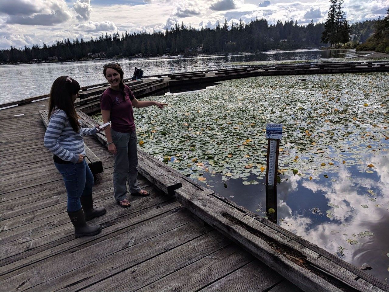 Jen Oden, Snohomish County Water Quality Specialist, and Megan Lane, LOCSS team member, report a lake height measurement at Flowing Lake, Snohomish County, Washington