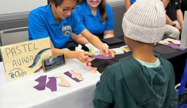 STEM Ambassadors assist a young boy in making a pastel aurora.
