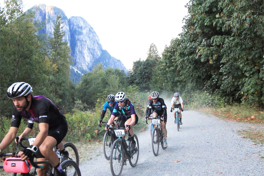 a group of cyclists racing on a gravel trail