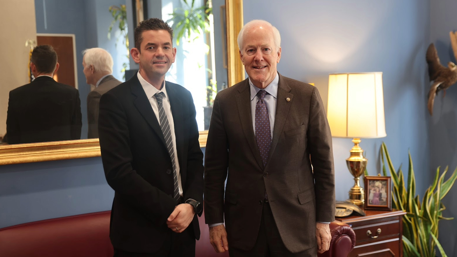 Two men in business suits smiling for a photograph