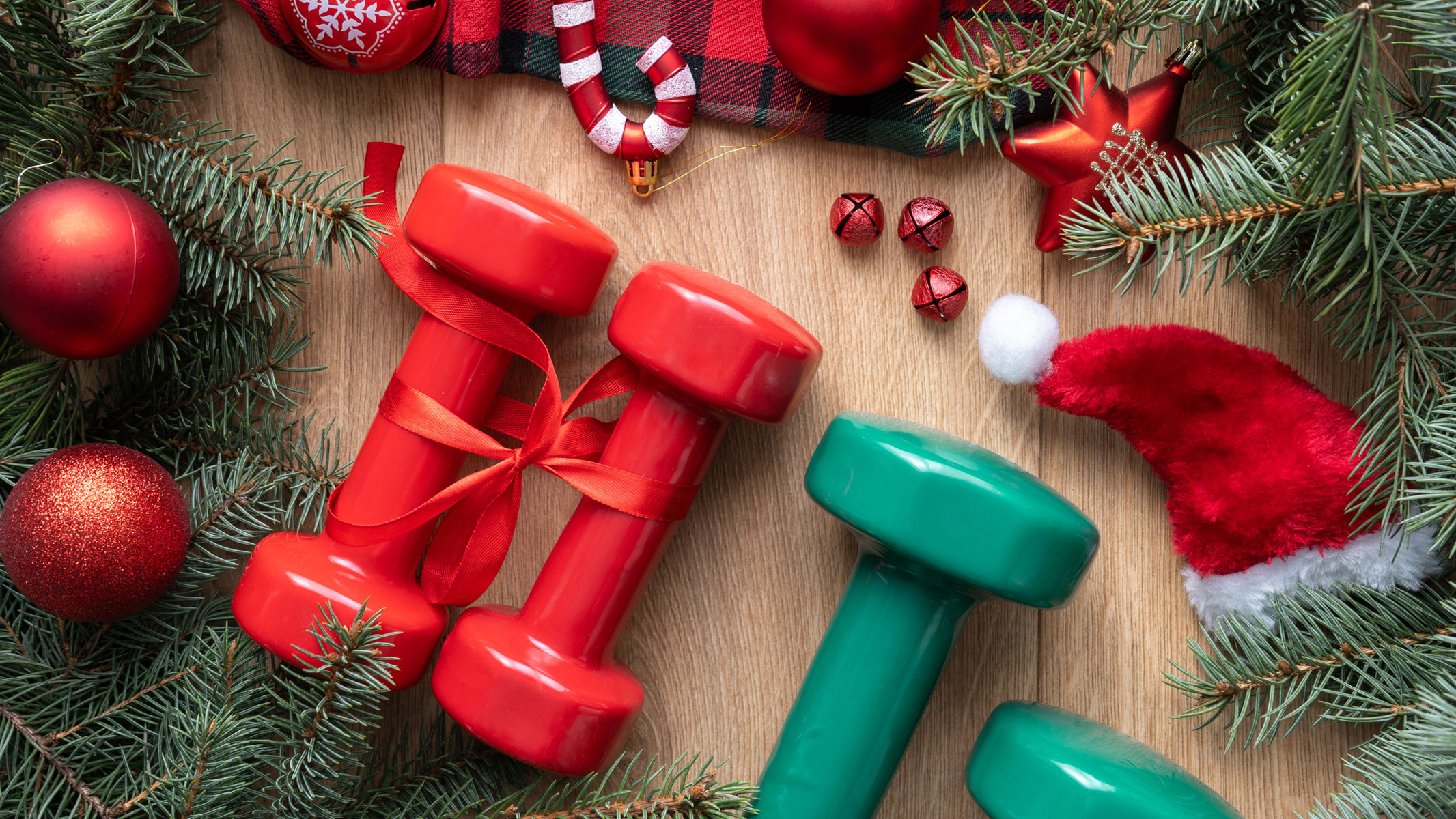 A picture of two pairs of small dumbbells lying among Christmas decorations