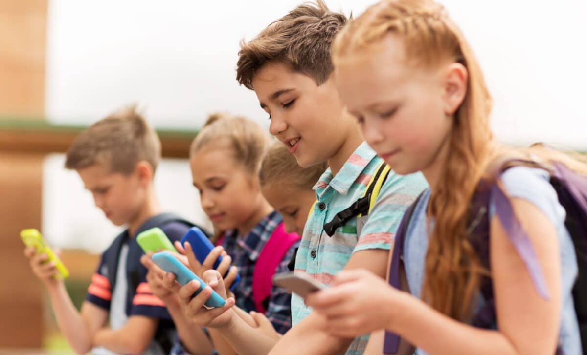 A Group Of Schoolchildren Using Their Smartphones