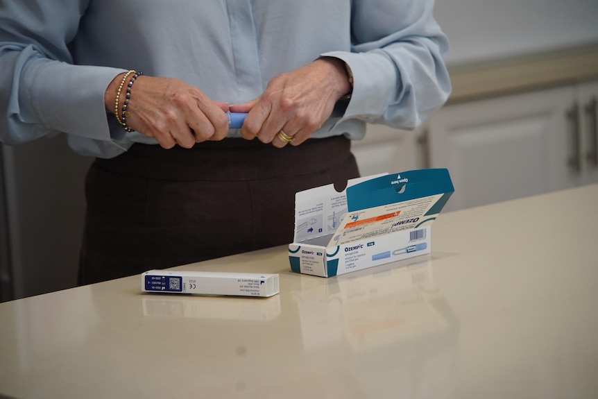 A picture of a woman holding medical weight-loss treatments.