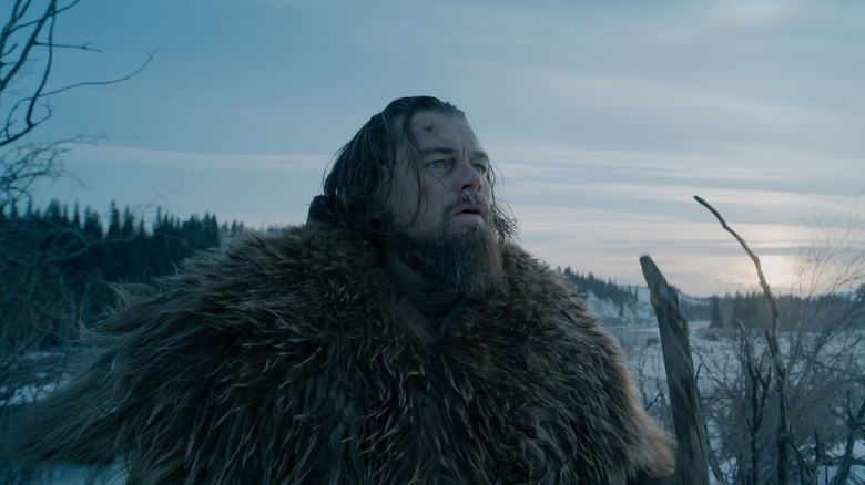 Glass looking up at the lightening sky in The Revenant