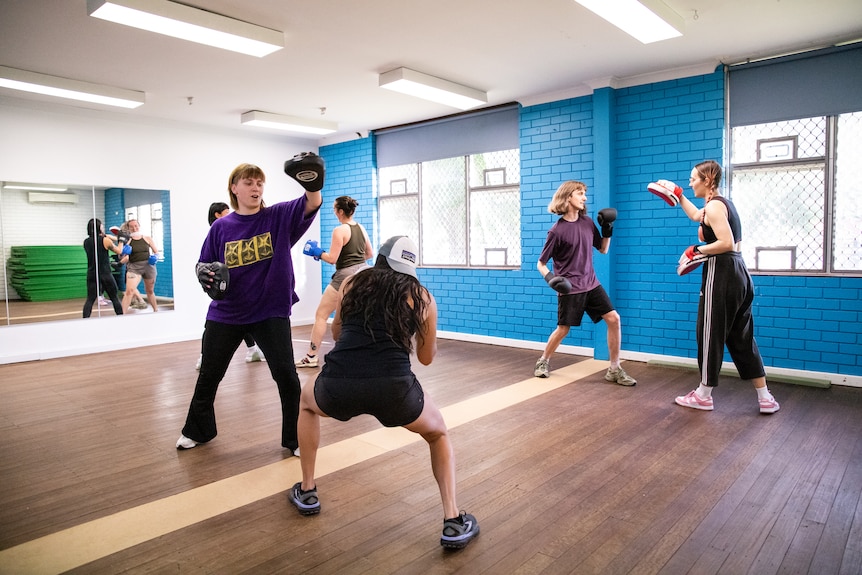 Participants smiling in a boxing class.